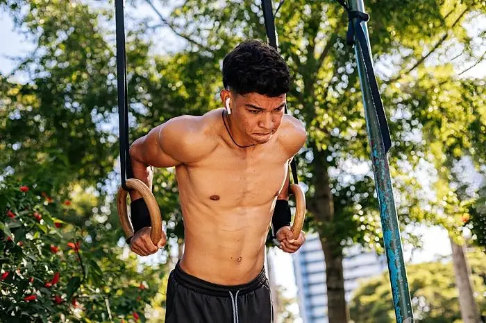 un ragazzo che si allena a calisthenics all'aperto in città