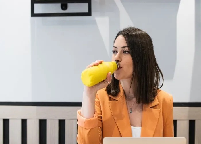 Una ragazza con una borraccia in ufficio